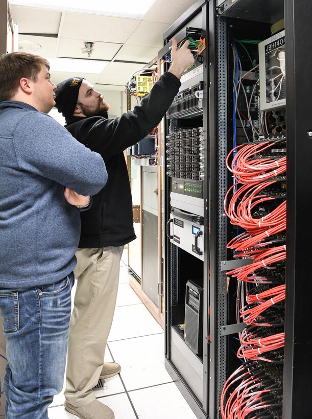 Dakota Aaron, right, an eSTARR hardware engineer, and Calvin Davis, an instrumentation, data and controls engineer, check the new network switch and data source computers in the Arnold Engineering Development Complex Engine Test Facility T-3 test cell data conditioning room at Arnold Air Force Base, Tenn., Dec. 3. The network switch and data source computers are part of upgrades to the test cell, including the new digital voltage scanners at the right. (U.S. Air Force photo by Jill Pickett)
