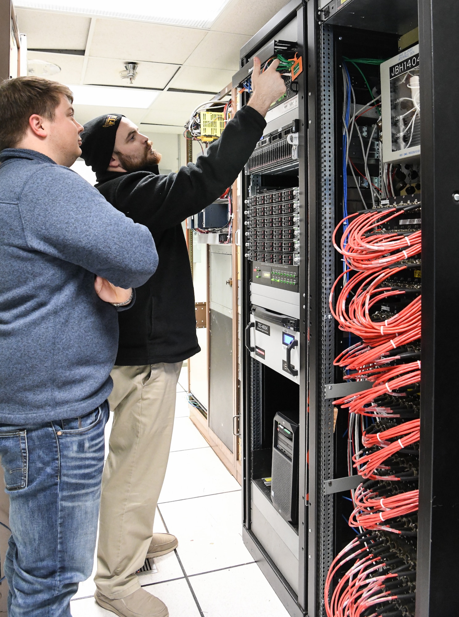 Dakota Aaron, right, an eSTARR hardware engineer, and Calvin Davis, an instrumentation, data and controls engineer, check the new network switch and data source computers in the Arnold Engineering Development Complex Engine Test Facility T-3 test cell data conditioning room at Arnold Air Force Base, Tenn., Dec. 3. The network switch and data source computers are part of upgrades to the test cell, including the new digital voltage scanners at the right. (U.S. Air Force photo by Jill Pickett)