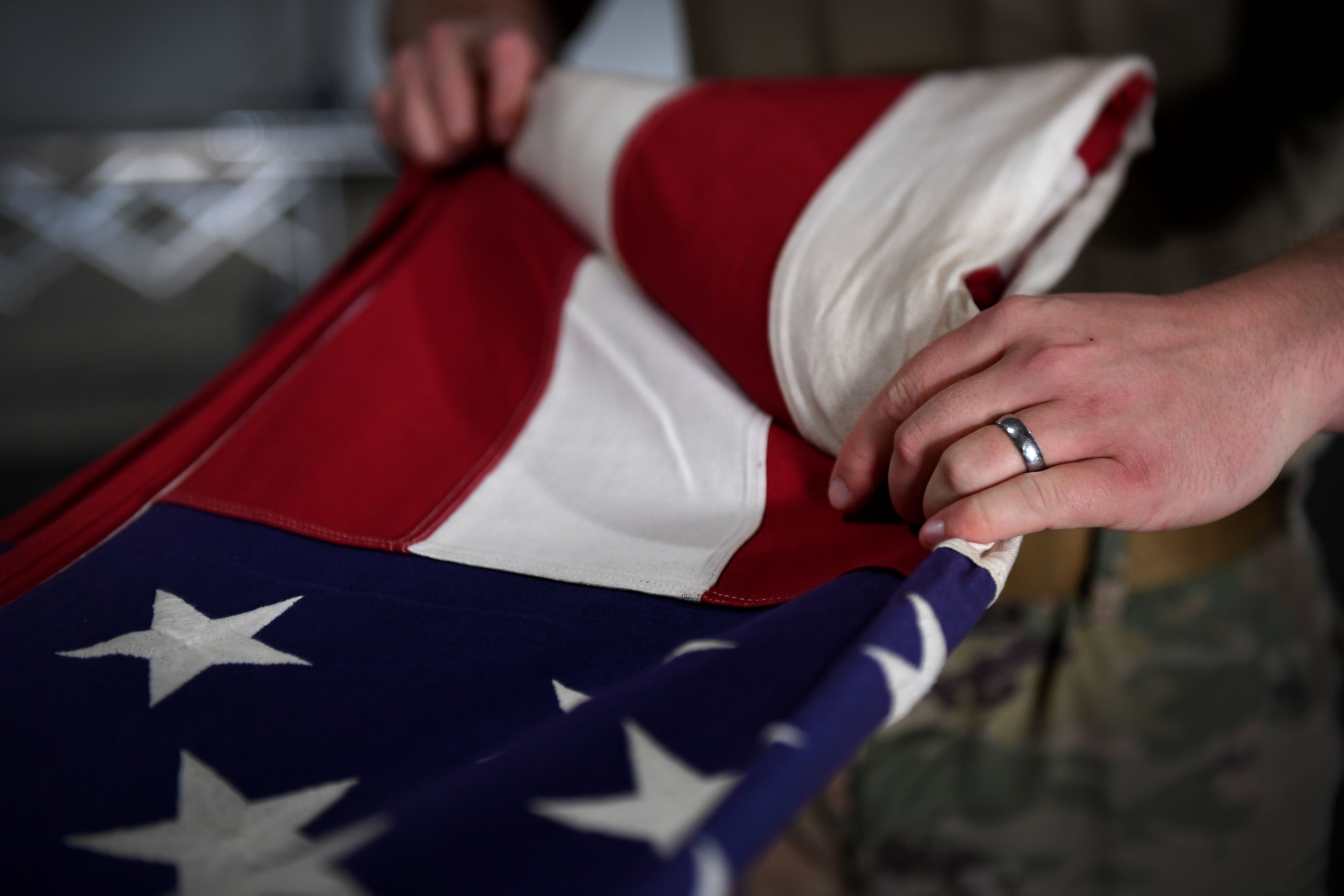 A man folds a flag.