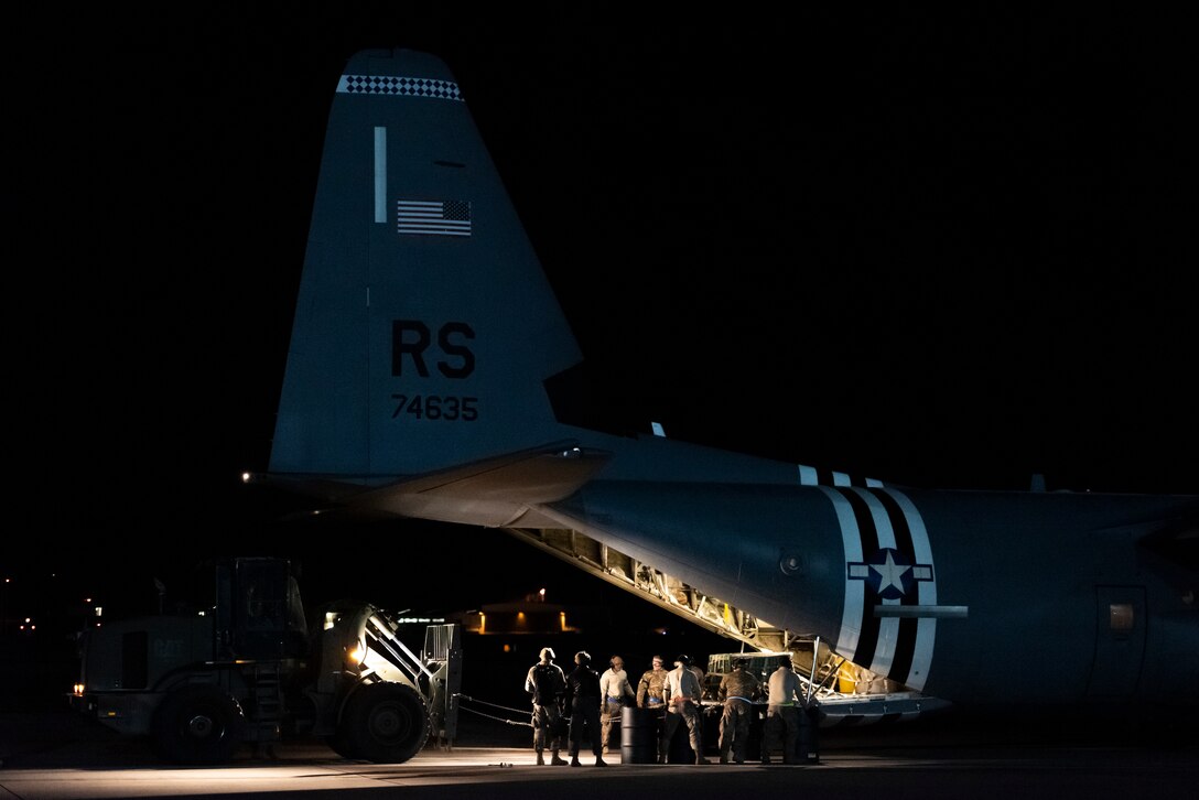 U.S. Airmen assigned to the 435th Contingency Response Squadron conduct combat offload method-B training at night during Exercise Agile Wolf at Ramstein Air Base, Germany, Dec. 17, 2019. Combat offload method-B allows the 37th Airlift Squadron to deploy cargo in austere locations without access to large mobility vehicles. (U.S. Air Force photo by Staff Sgt. Devin Nothstine)