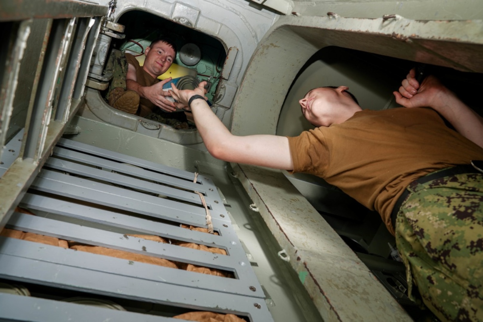 SANTA RITA, Guam (Jan. 3, 2020) Electronics Technician (Nuclear) 3rd Class Andrew Wood, from San Antonio, passes a can of food to Culinary Specialist (Submarine) Seaman William Minge, from Lebanon, Ohio, in the auxiliary tank during an onload of provisions aboard the Los Angeles-class fast attack submarine USS Key West (SSN 722). Key West is one of four forward-deployed submarines assigned to Commander, Submarine Squadron Fifteen out of Polaris Point, Guam.