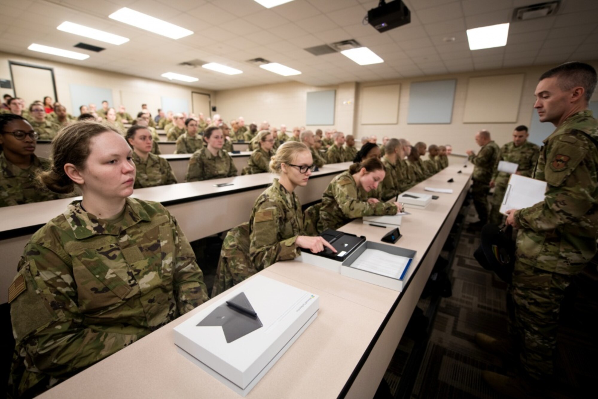 U.S. Air Force basic military training trainees are issued personal computers during in-processing as part of a pilot test under a Cooperative Research and Development Agreement partnership at Joint Base San Antonio-Lackland, Texas, Dec. 11, 2019. The computers replace all hard copy textbooks BMT trainees currently use with the intent to help BMT assess learning outcomes, value and return on investment. (U.S. Air Force photo by Sarayuth Pinthong)