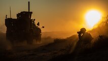 A U.S. Marine photographs a Mine Resistant Ambush Protected All-Terrain Vehicle during a tactical vehicle driving course in Kuwait, Dec. 21.