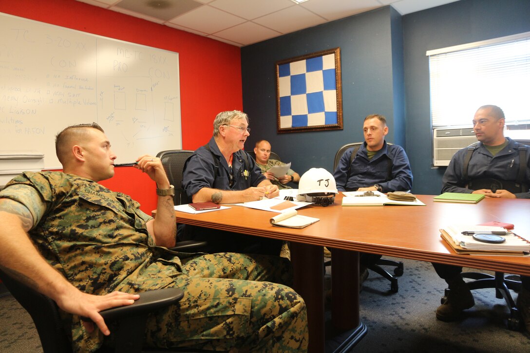 Tommy “TJ” Pittman, seated at the head of the table, reviews changes made to technical manuals during the logistics demonstration with Staff Sgt. Matthew Champlain, Gunnery Sgt. James Bruce, Staff Sgt. Justin Hanush and Staff Sgt. Josh Pena. Pittman served the amphibious assault community for nearly 50 years, first as an enlisted amphibious vehicle operator for 24 years, then as a logistician with the Advanced Amphibious Assault program office at Program Executive Officer Land Systems for another 24 years. Pittman retired from federal civil service in December 2019. (U.S. Marine Corps photo by Ashley Calingo)