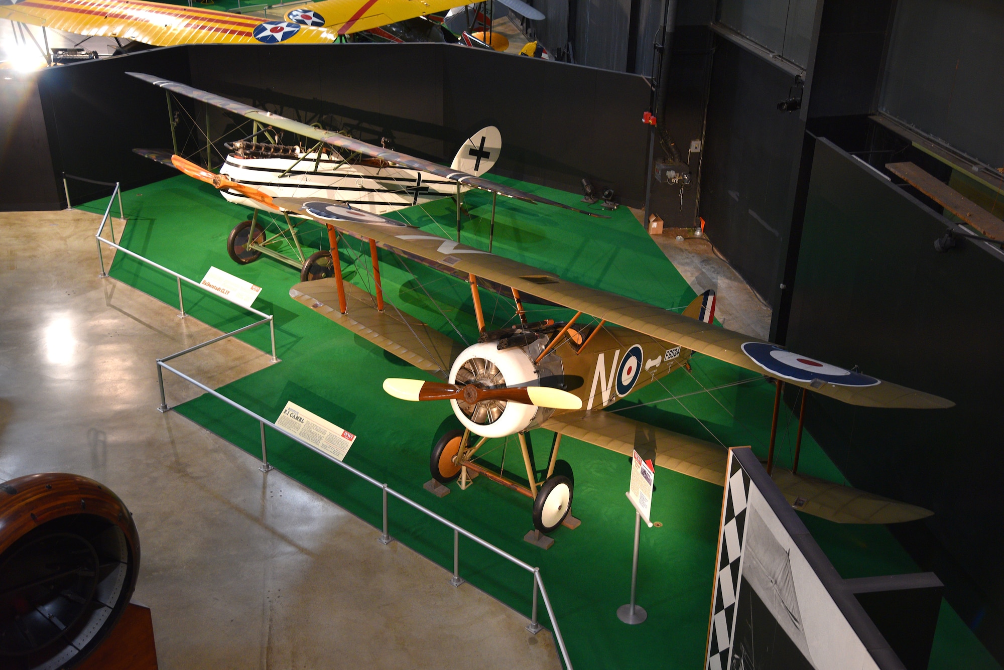 Two early years aircraft on display. These are fixed wing biplanes that are driven by propellers.
