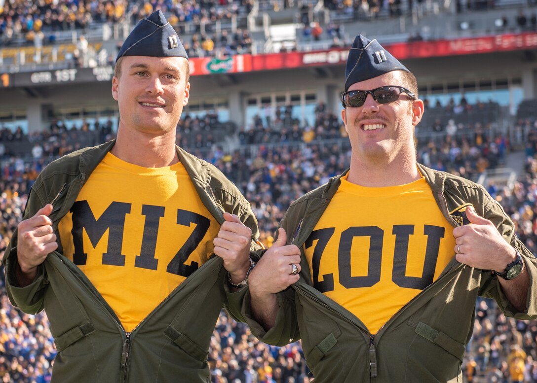 Capt. Mitch Mabee and Capt. Kyle Cassady, B-2 Spirit pilots assigned to the 509th Bomb Wing at Whiteman Air Force Base, Missouri, reveal their Mizzou shirts during the University of Missouri military appreciation game on Nov. 16, 2019, at Memorial Stadium, Columbia, Missouri. During the game a B-2 Spirit Stealth Bomber performed a flyover, Airmen laid a ceremonial wreath and 509th Base Commander Col. Jeffrey Schreiner pumped up the crowd by hitting the Big MO bass drum. (U.S. Air Force photo by Senior Airman Thomas Barley)