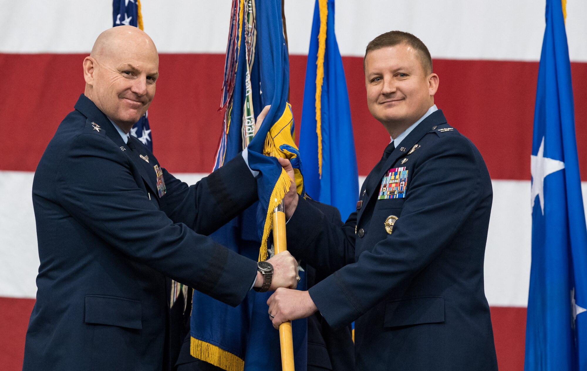 Maj. Gen. Sam C. Barrett, left, 18th Air Force commander, presents the 436th Airlift Wing guidon to Col. Matthew Jones, incoming 436th AW commander, during a change of command ceremony Jan. 7, 2020, inside the 436th Aerial Port Squadron, on Dover Air Force Base, Del. Upon taking command, Jones became the wing’s 35th commander. (U.S. Air Force photo by Roland Balik)