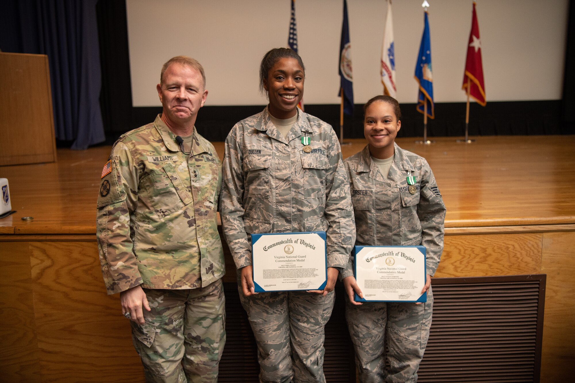 three Airmen pose with certificates