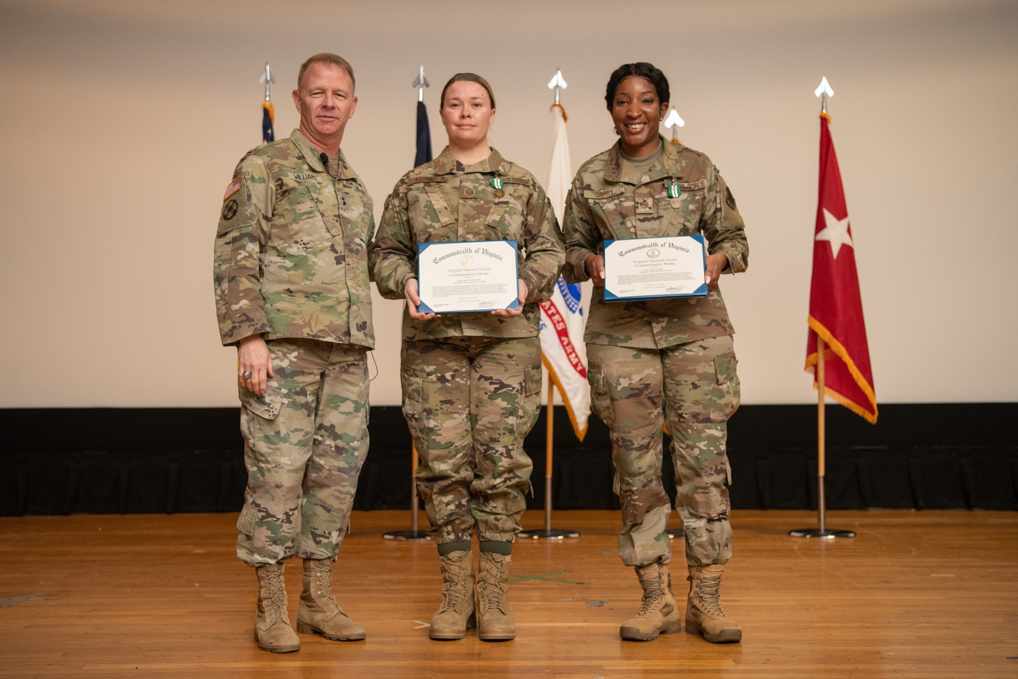 three Airmen pose with certificates