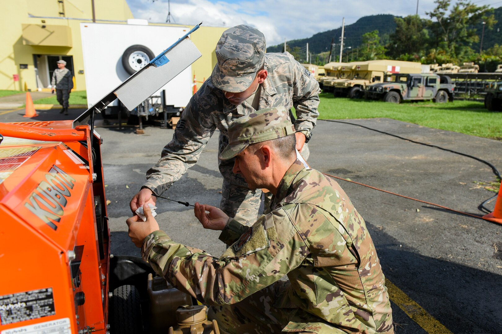 U.S. Air Force Staff Sgt. Edwin Marrero, left, a cyber infrastructure technician and Senior Airman Edwardo Mendez, an information technology specialist with the 156th Communications Flight at Muñiz Air National Guard Base, Puerto Rico Air National Guard, perform maintenance on a generator f in Cayey, Dec. 27, 2019. Airmen from the 156th Wing were activated to support state and federal operations working to stabilize a vegetation debris fire that has been burning underground in Cayey since Nov. 28, 2019.