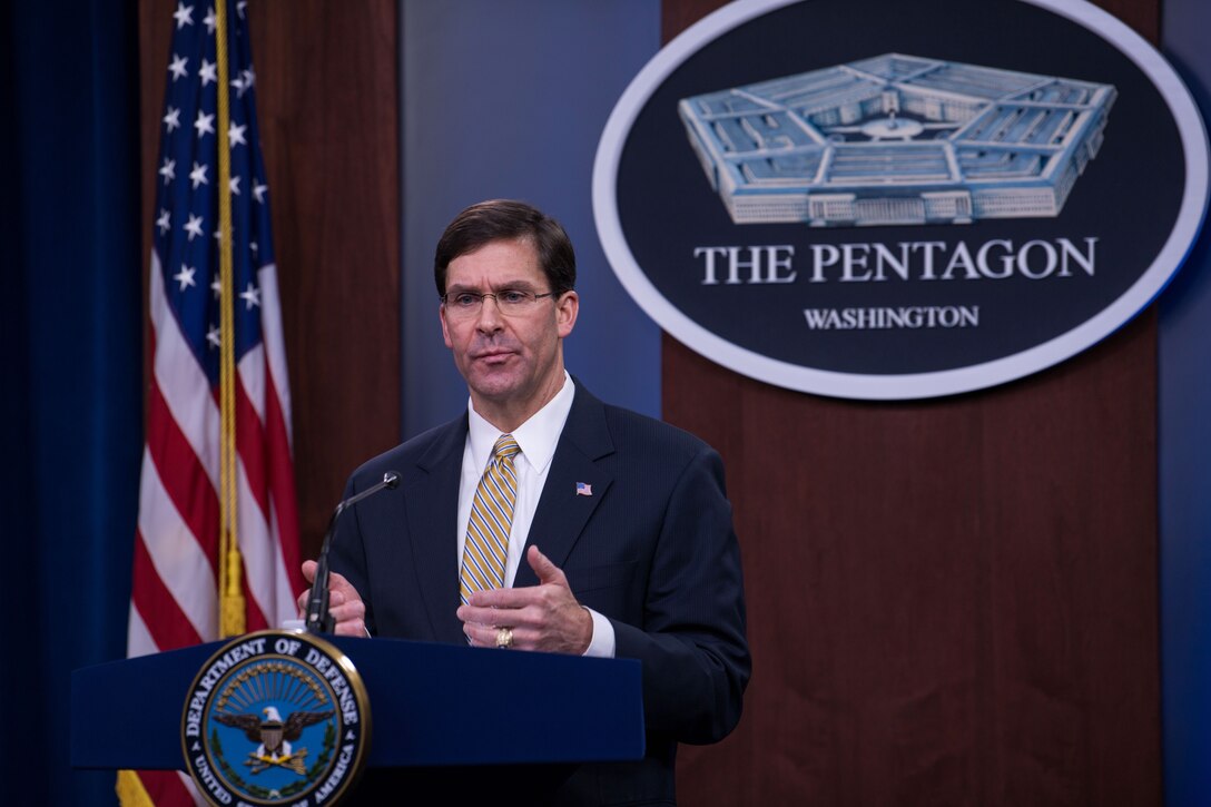 A man stands at a podium with the Defense Department logo on it.