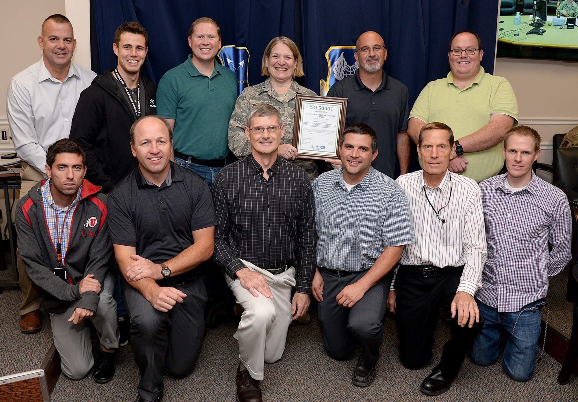 Brigadier Gen. Constance Jenkins, mobilization assistant to the commander for the Ogden Air Logistics Complex, and 12 members of the complex energy team pose for a group photo with the recently presented ISO 50001 certificate.