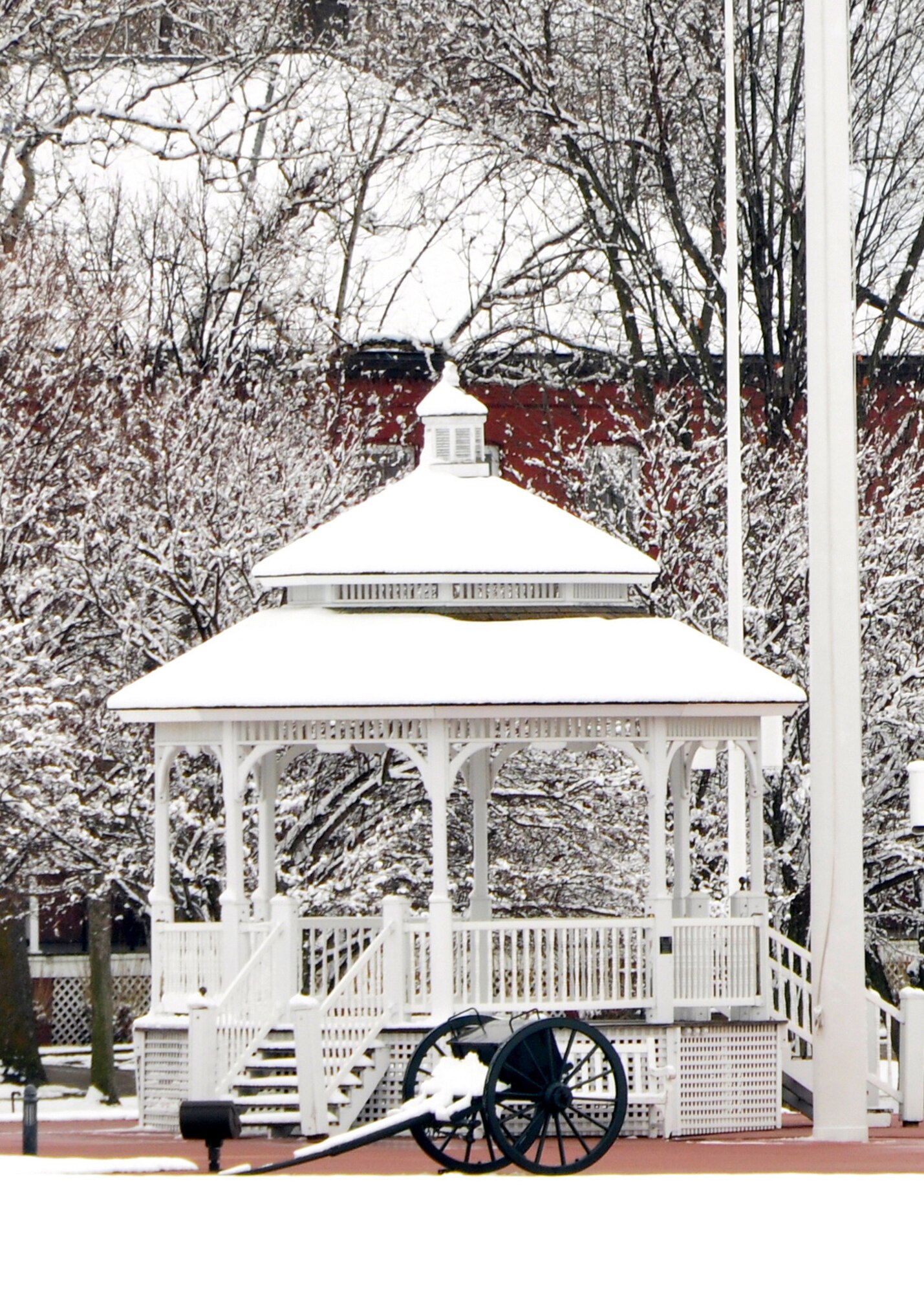 snow resting on gazebo on parade grounds, with cannon in the foreground