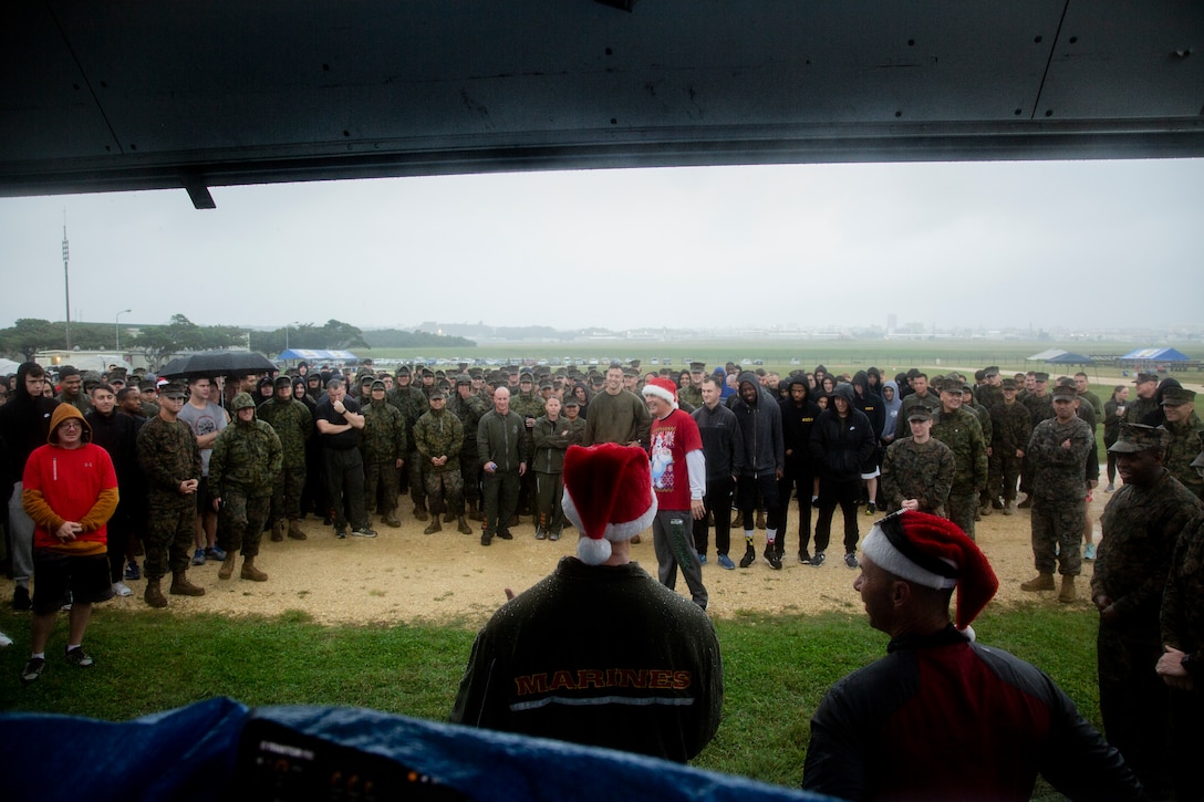 U.S. Marines with Marine Corps Air Station (MCAS) Futenma gather around Col. David Steele, commanding officer, for the opening remarks on MCAS Futenma, Okinawa, Japan, Dec. 6, 2019. The Jingle Bell challenge is a time for Marines who are far away from home to build unit morale during the holiday season. (U.S. Marine Corps photo by Cpl. Sarah  Stegall)