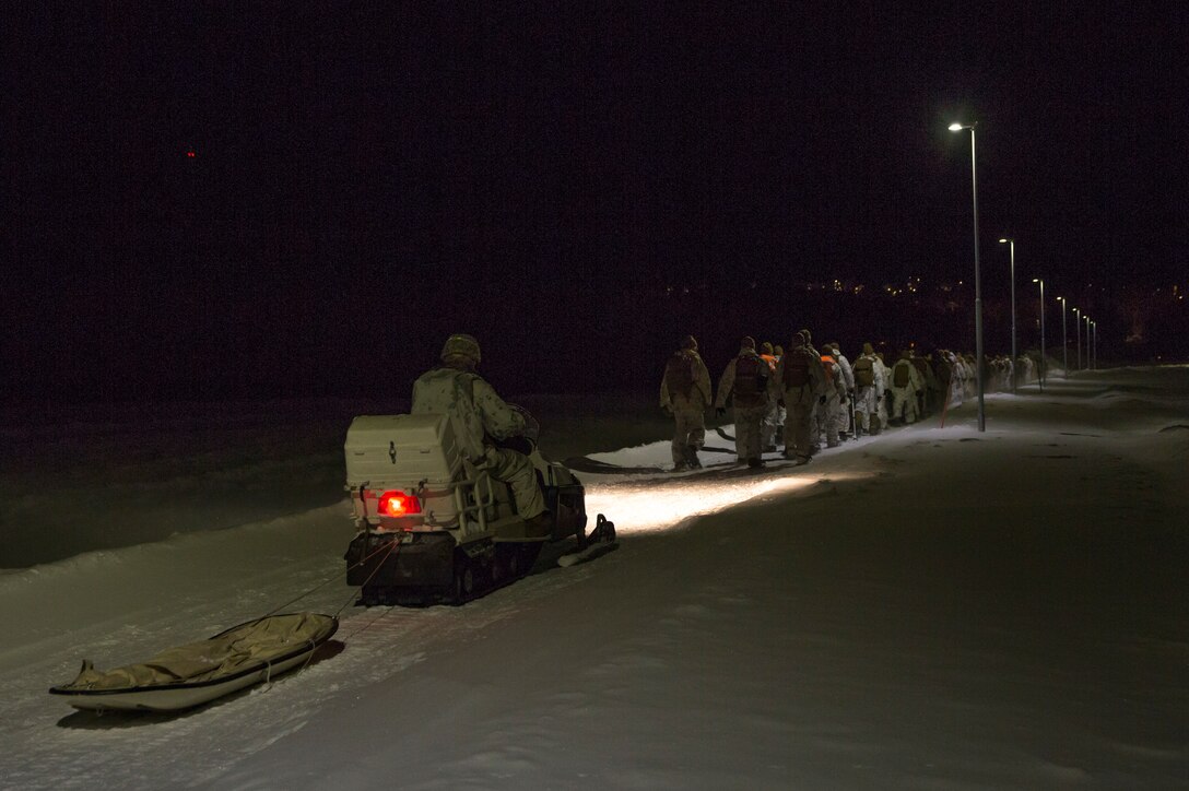 U.S. Marines with Marine Rotational Force-Europe 20.1, Marine Forces Europe and Africa, maneuver across a field during a 4k hike in Setermoen, Norway, Dec. 27, 2019. Snow shoes were utilized throughout the entire duration of the 4k hike to sustain over-the-snow mobility. MRF-E focuses on regional engagements throughout Europe by conducting various exercises, arctic cold-weather and mountain-warfare training, and military-to-military engagements, which enhance overall interoperability of the U.S. Marine Corps with allies and partners. (U.S. Marine Corps photo by Sgt. Justin X. Toledo)