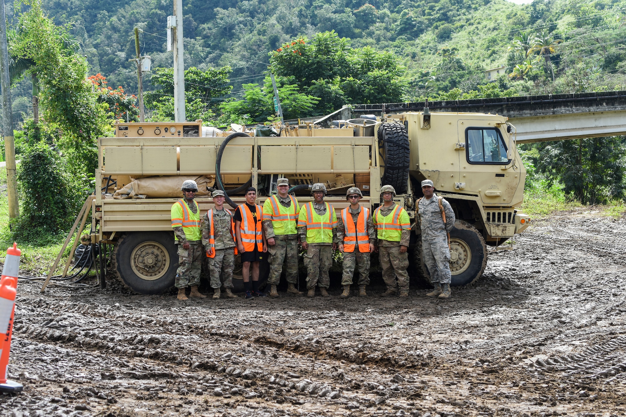 U.S. Air Force Airmen, assigned to the 156th Wing, Puerto Rico Air National Guard, and U.S. Army Soldiers, assigned to the 482nd Chemical Company, Puerto Rico National Guard, pose in front of a vehicle near Rio de la Plata, Puerto Rico, Dec. 27, 2019. Members of the Puerto Rico National Guard were activated to support state and federal operations working to stabilize the vegetation debris fire that has been burning underground in Cayey, Puerto Rico, since Nov. 28, 2019. (U.S. Air National Guard photo by Master Sgt. Caycee Watson)