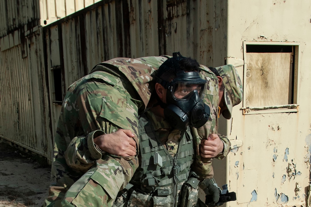 A soldier carries another soldier over his shoulders.