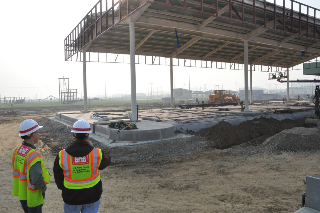 Craig Margrave (left), POL-MCX mechanical engineer, and Michael Merwald, POL-MCX electrical engineer, inspect a retail fueling facility under construction at Camp Humphreys, Korea.  Photo by Greg Etter.