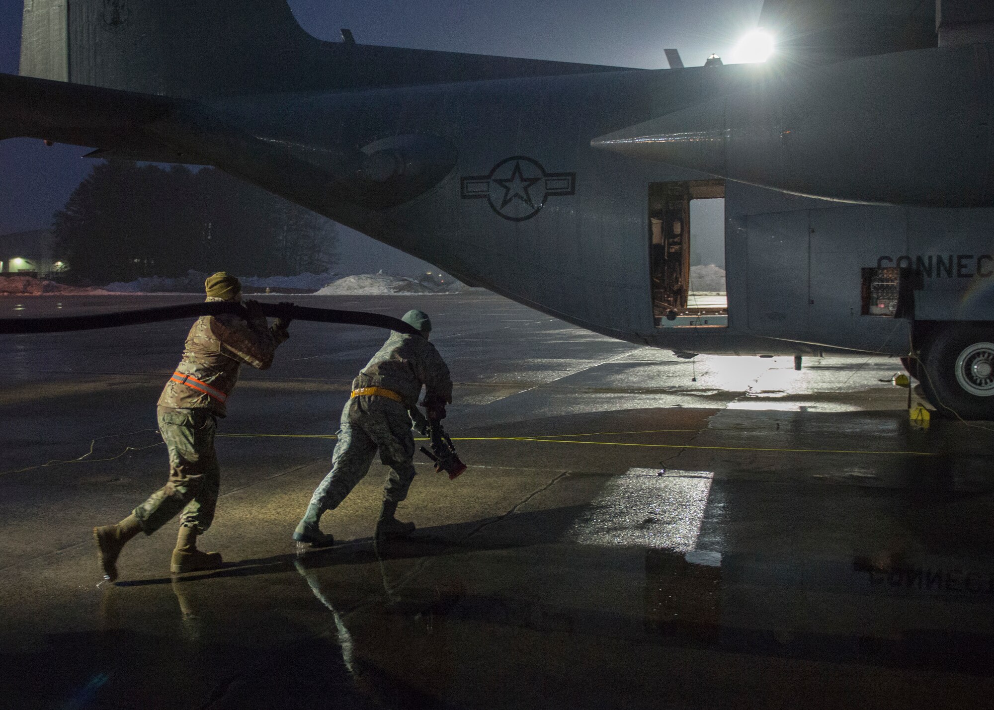 U.S. Air Force Staff Sgt. Max Feinstein (left), an aircraft crew chief assigned to the 103rd Logistics Readiness Squadron, and Master Sgt. Nicola Nardi, the fuels operations noncommissioned officer in charge assigned to the 103rd Logistics Readiness Squadron, prepare to refuel a C-130H Hercules from the 103rd Airlift Wing, Connecticut Air National Guard, at Bradley Air National Guard Base, East Granby, Conn. Jan. 4, 2020. Fuels Airmen support aircraft with jet fuel and liquid oxygen and test the fuel to ensure it meets Air Force specifications. (U.S. Air National Guard photo by Staff Sgt. Steven Tucker)