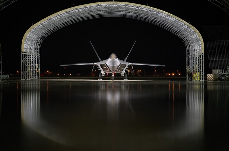 An Air Force F-22 Raptor is parked on the flightline