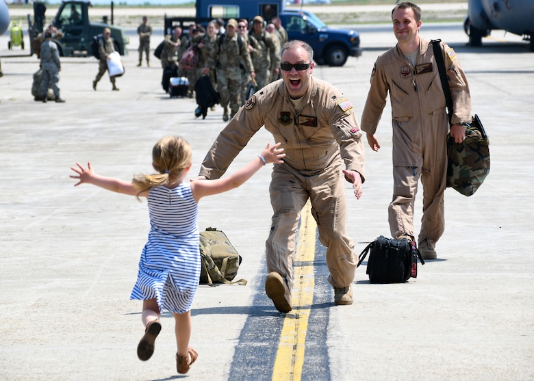 An Airman reunites with a family member as he returns home from their recent deployment
