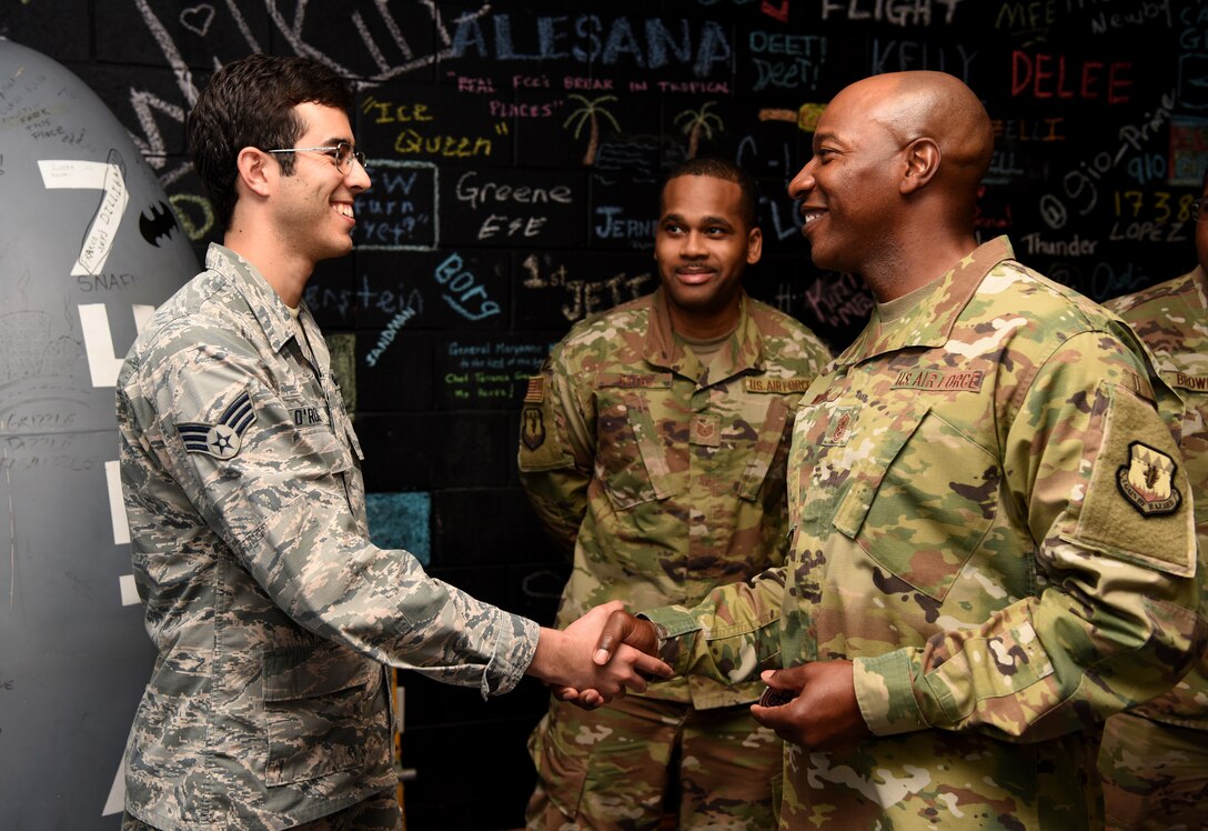 CMSAF presents a coin to Senior Airman