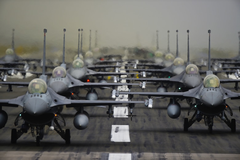 F-16 Fighting Falcons line up in formation on the runway