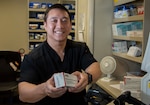 Huy Nguyen, pharmacist, dispenses a prescription in the main pharmacy at Brooke Army Medical Center, Joint Base San Antonio-Fort Sam Houston.