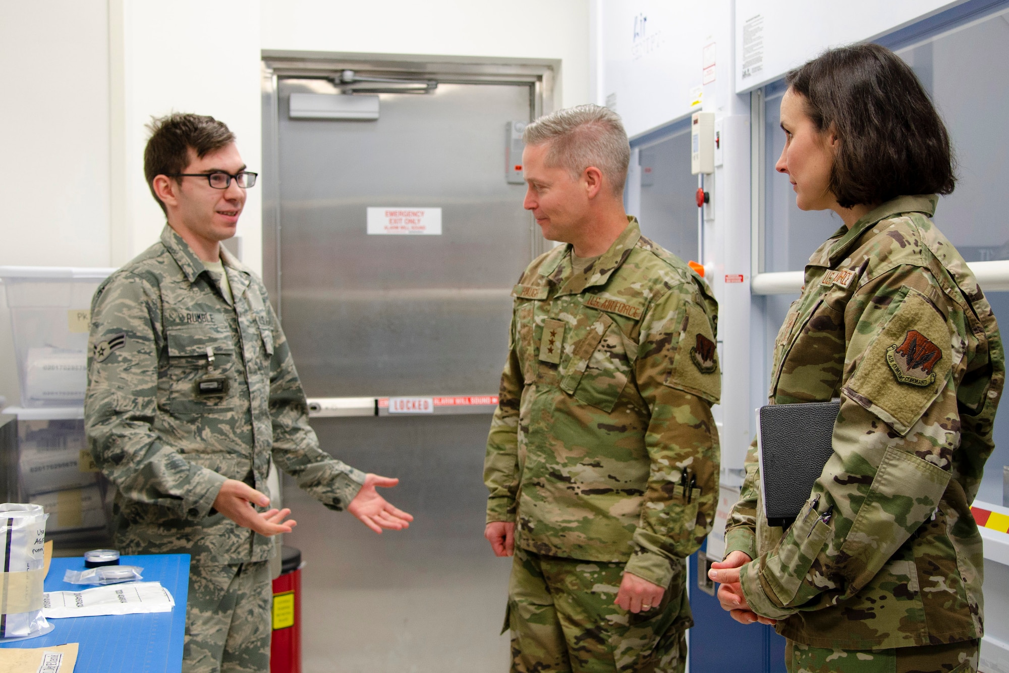 Airman 1st Class Ethan Rumble (left), a sample control technician at the Air Force Radiochemistry Laboratory, Patrick AFB, Fla., describes to 16th Air Force (Air Forces Cyber) Commander Lt. Gen. Timothy Haugh (center) and 16th AF Command Chief Master Sgt. Summer Leifer how he processes radiologic samples that arrive at the lab for analysis as part of the Air Force Technical Applications Center's nuclear treaty monitoring mission.  Haugh and Leifer traveled from San Antonio to get a glimpse into AFTAC's instrumental role in 16th AF's information and multi-domain operations. (U.S. Air Force photo by Susan A. Romano)