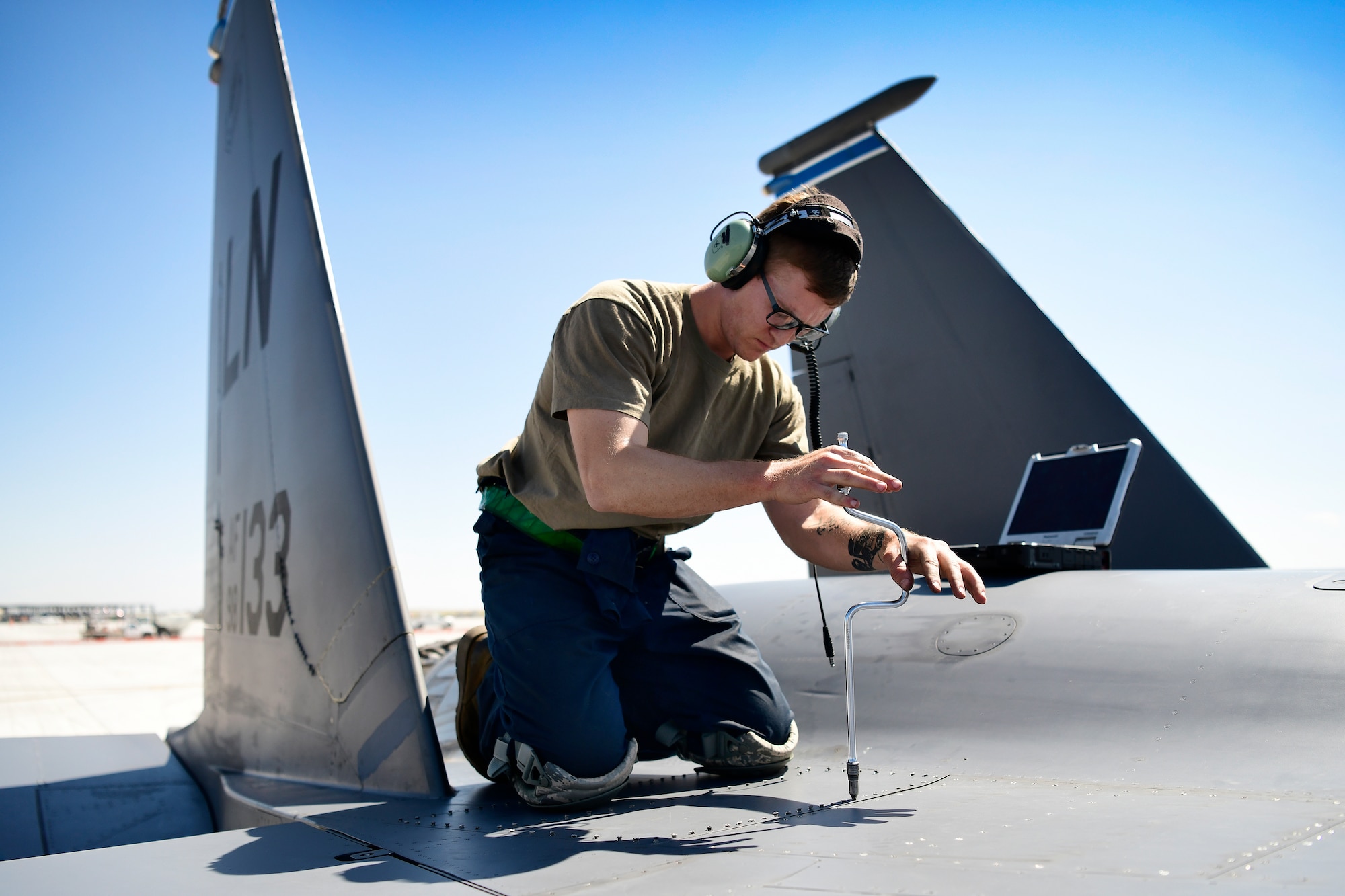 Senior Airman secures a panel on an F-15E Strike Eagle