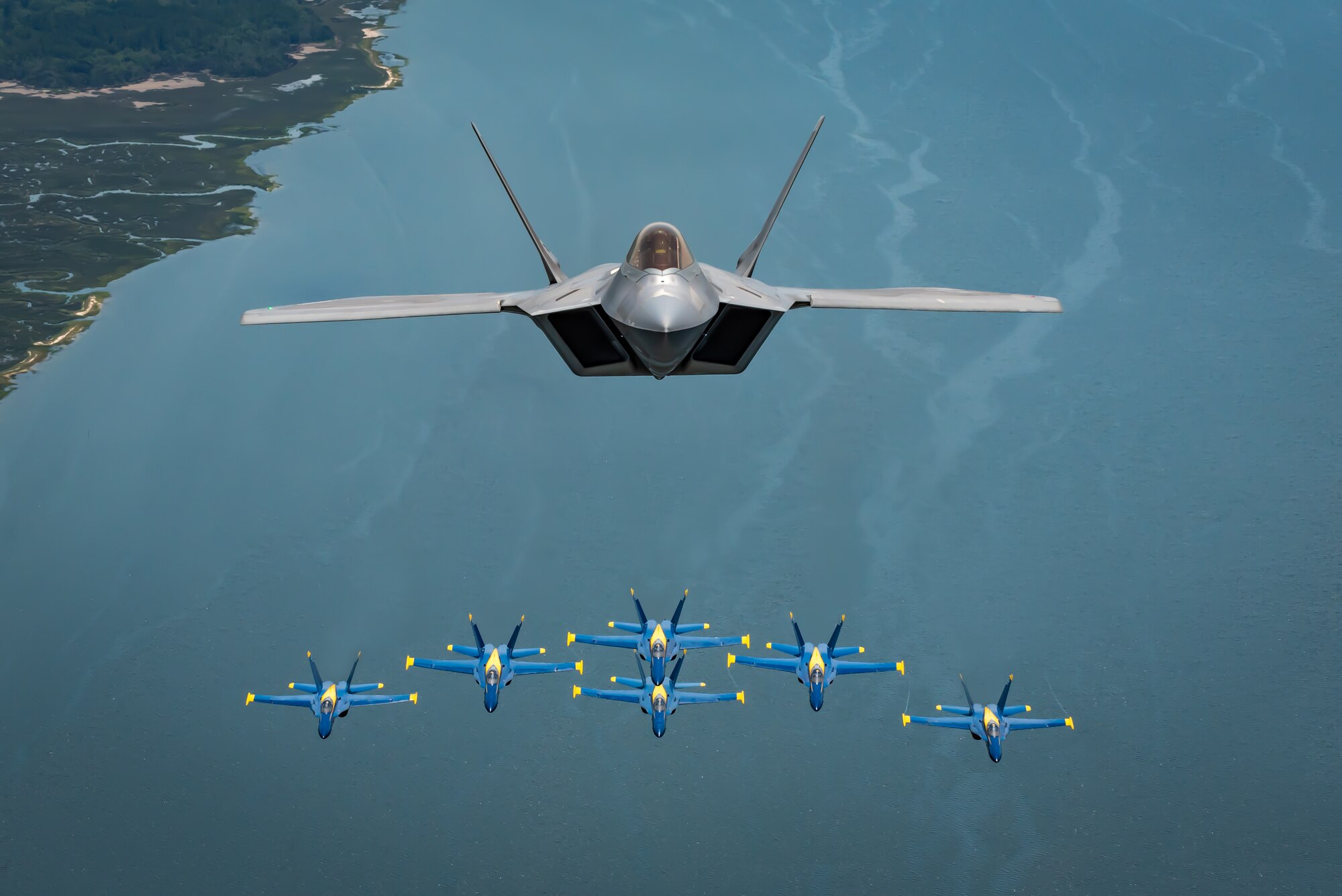 F-22 Demonstration Team flies above the U.S. Navy Blue Angels
