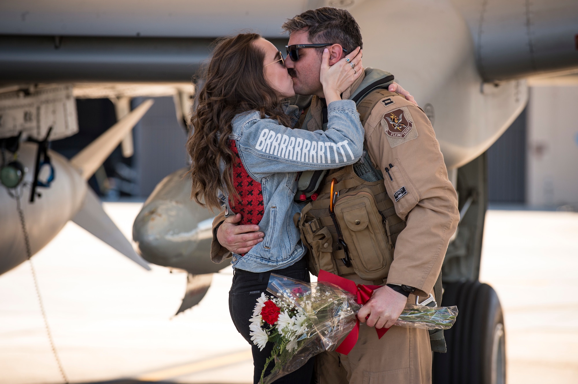 An A-10C Thunderbolt II pilot and his girlfriend share an embrace