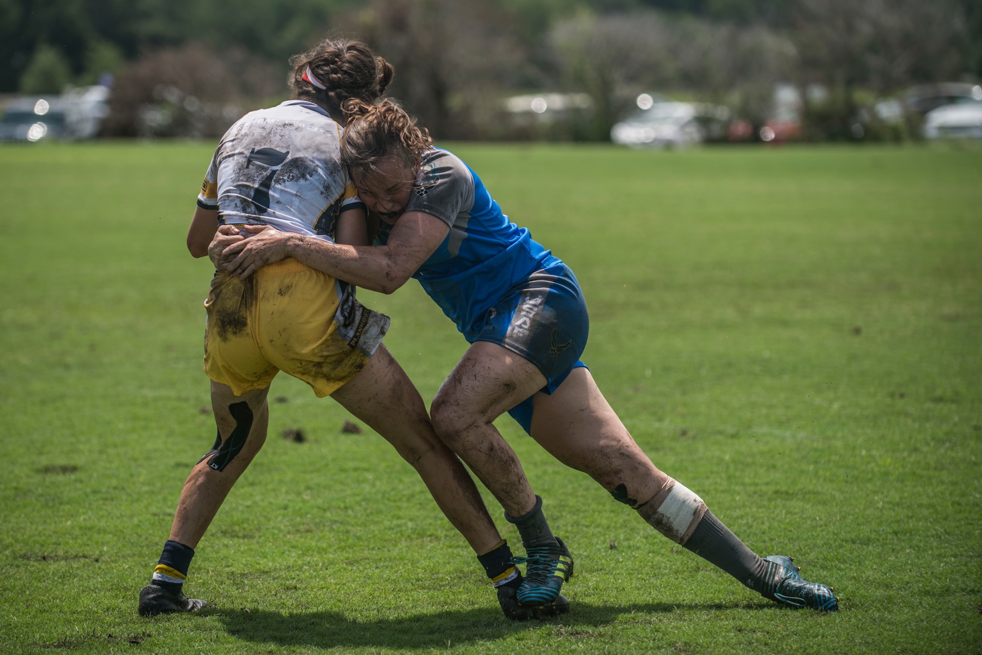 An Air Force rugby player tackles a Navy rugby player during a tournament