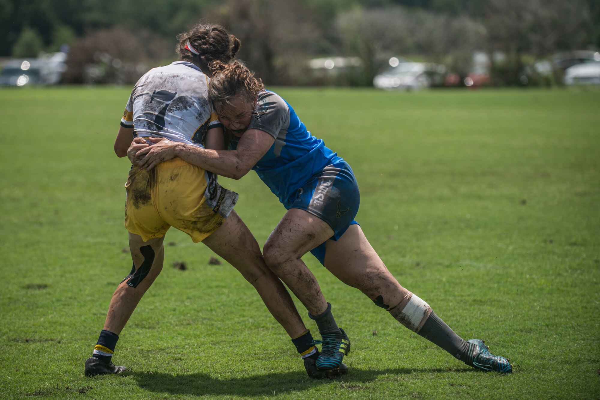 An Air Force rugby player tackles a Navy rugby player during a tournament