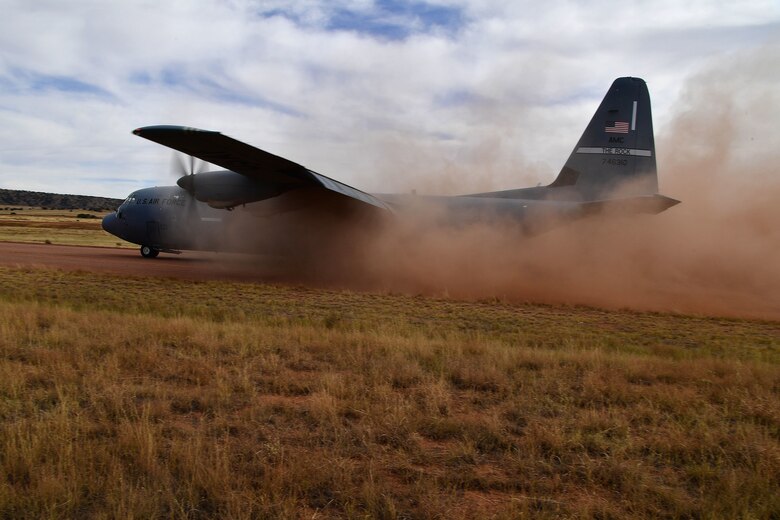 A C-130J Hercules prepares to take off from a dirt runway