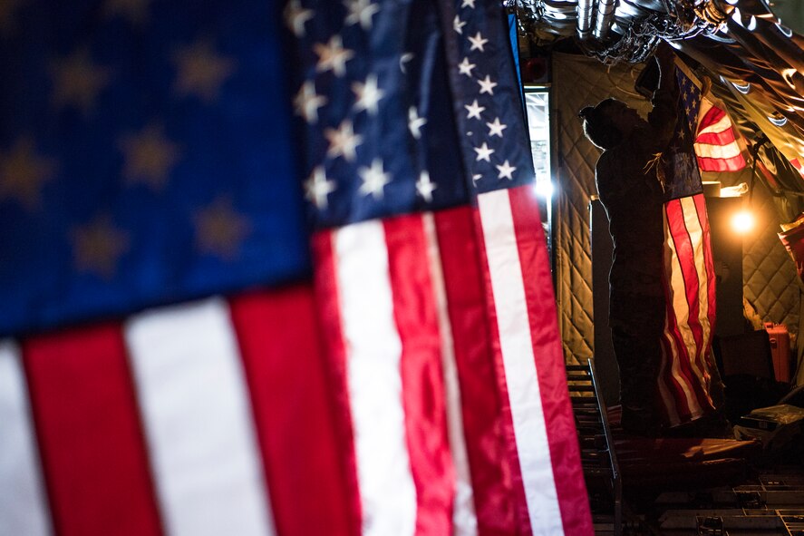 Pilot hangs the American flag inside a KC-135 Stratotanker