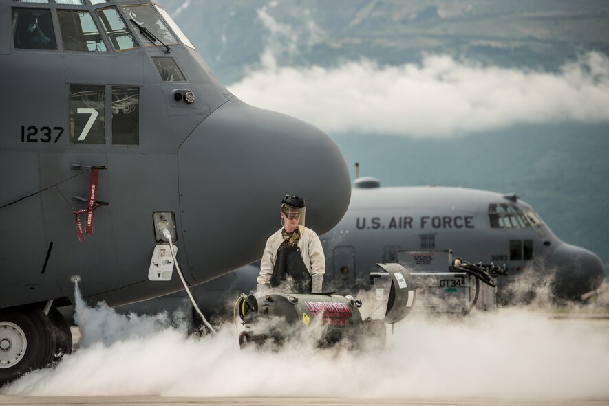 Senior Airman services the liquid oxygen system of a C-130 Hercules