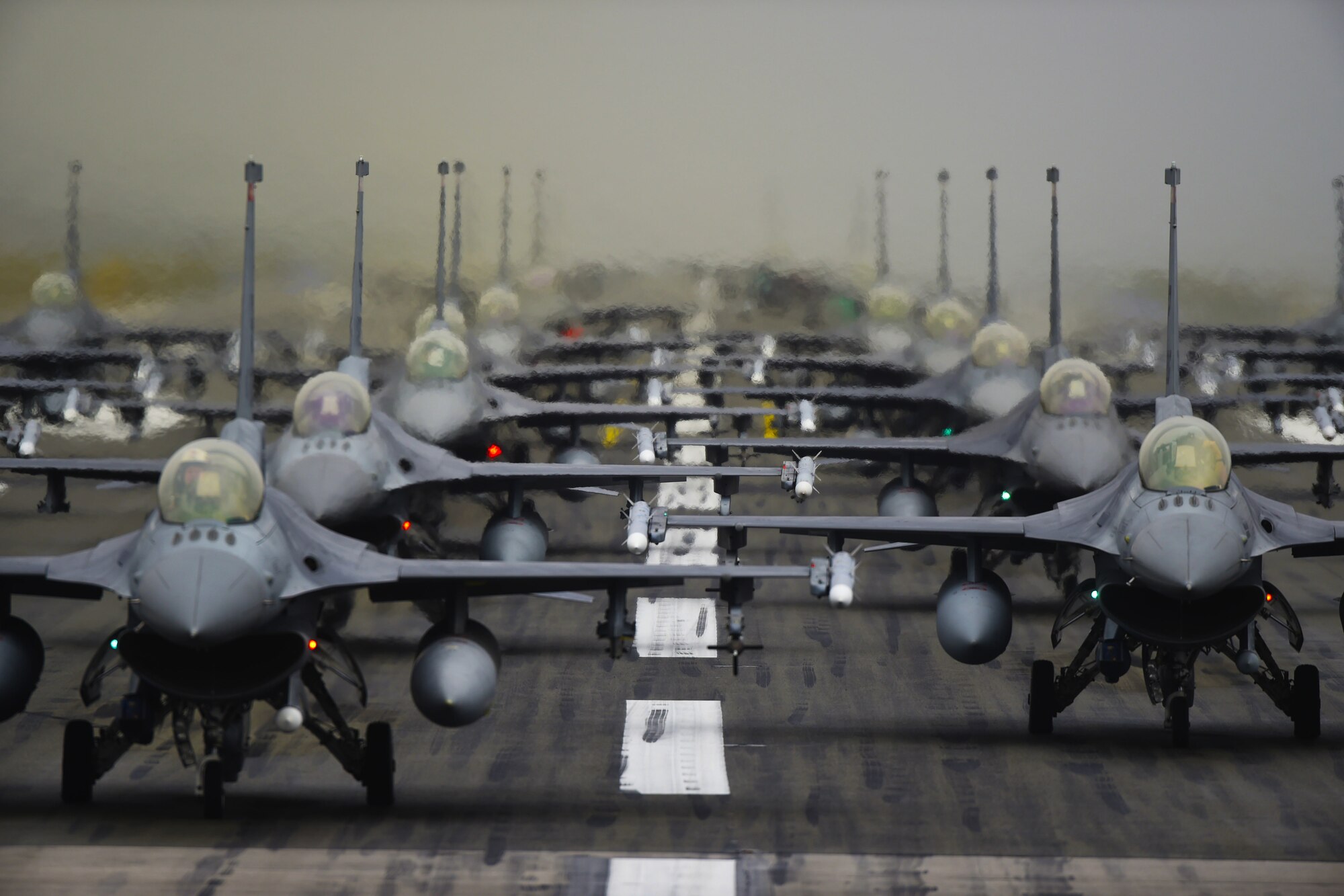 F-16 Fighting Falcons line up in formation on the runway