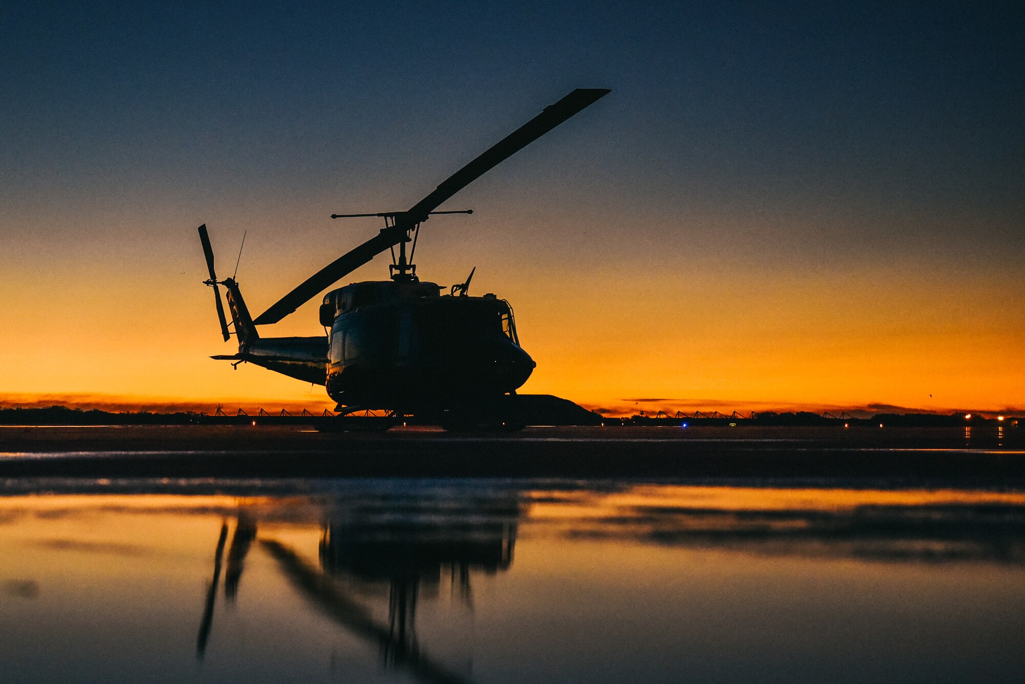 A UH-1N Iroquois sits on the flightline