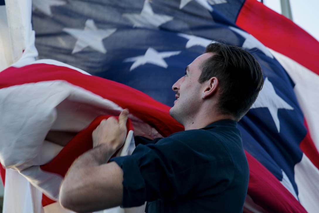 A sailor holds onto a flag.