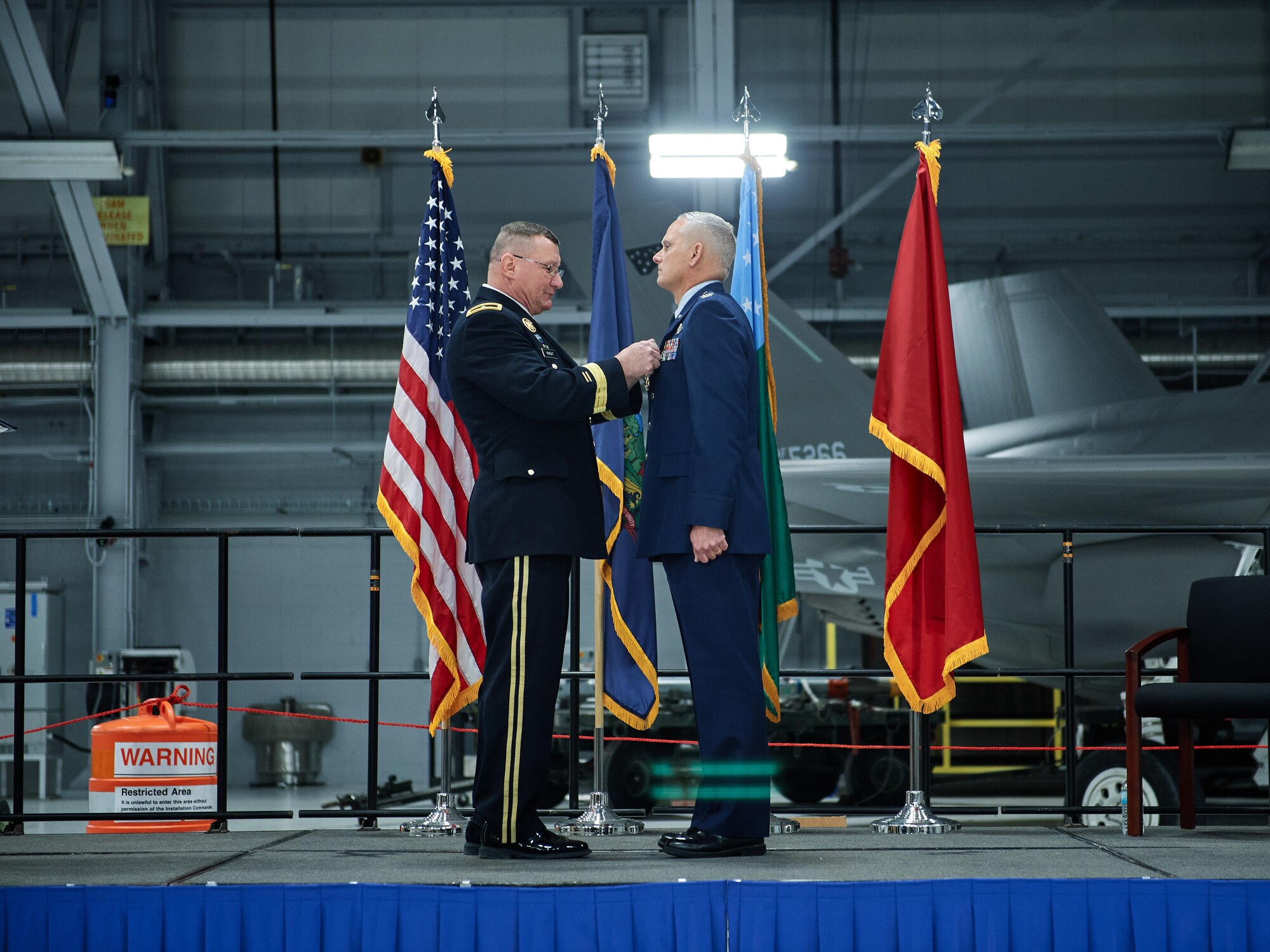 Army Brig. Gen. Greg Knight, the adjutant general of the Vermont National Guard, presents Col. David Smith, outgoing commander of the 158th Fighter Wing, Vermont Air National Guard, the Legion of Merit for his leadership of the wing