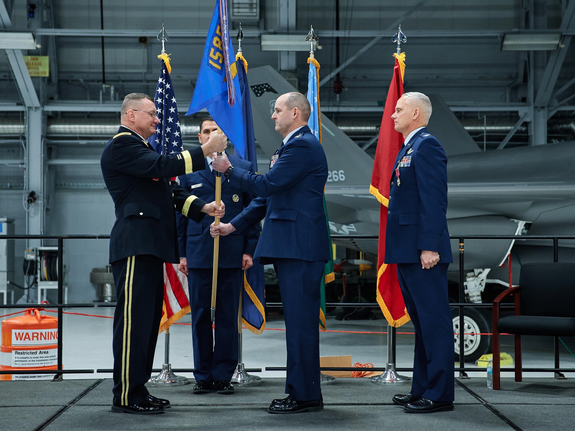 Col. David Shevchik, incoming commander of the 158th Fighter Wing, Vermont Air National Guard, takes the wing guidon from Army Brig. Gen. Greg Knight