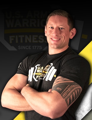 Man with brown hair and tattoo on left arm, in black t-shirt crossing his arms against a black, yellow and white background.