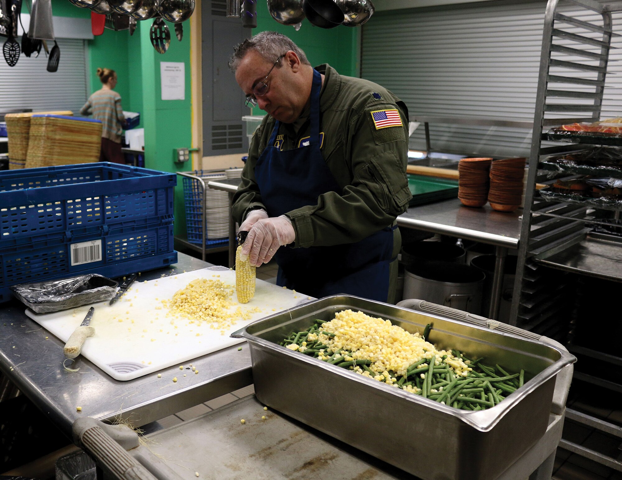 Lt. Col. Jerry Quincy, director of operations for the 89th Airlift Squadron, cuts corn off the cob while volunteering at the House of Bread in Dayton, Ohio Dec. 8, 2019. The House of Bread serves nearly 250 people a day. (U.S. Air Force photo/Staff Sgt. Joel McCullough)