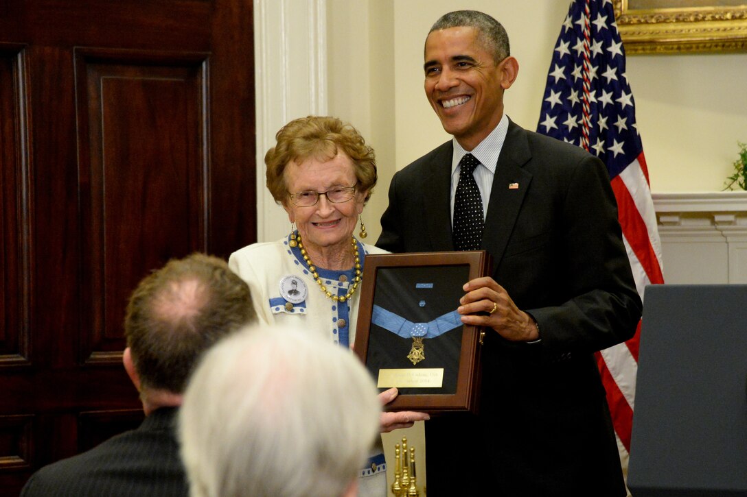 President Barack Obama and the descendant of a Civil War soldier hold up a plaque that encases that soldier’s Medal of Honor.