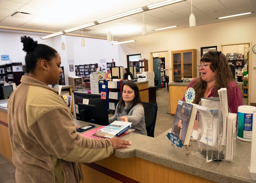 Shayla Tait, library patron, checks out her books from Roxanne Bangs, 366th Force Support Squadron library circulation services technician, and Debbie Worthington, 366th Force Support Squadron library supervisor, Jan. 2, 2020, at the library on Mountain Home Air Force Base, Idaho. The library has books that focus on military challenges such as reintegration, Post Traumatic Stress Disorder and families coping with deployments. (U.S. Air Force photo by Airman 1st Class Akeem K. Campbell)