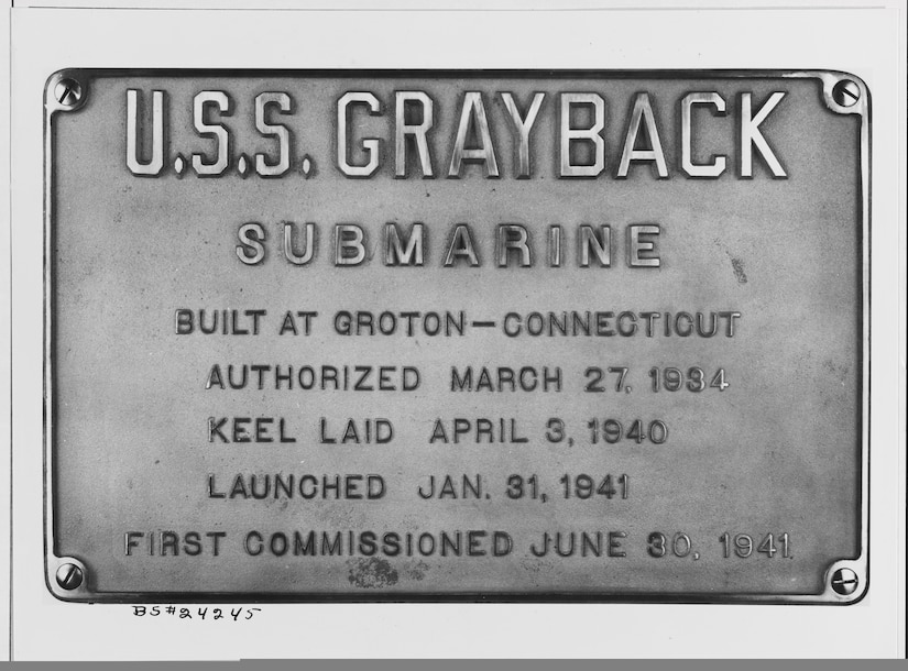 A plaque reads "USS Grayback," amid other descriptions of its launching details.