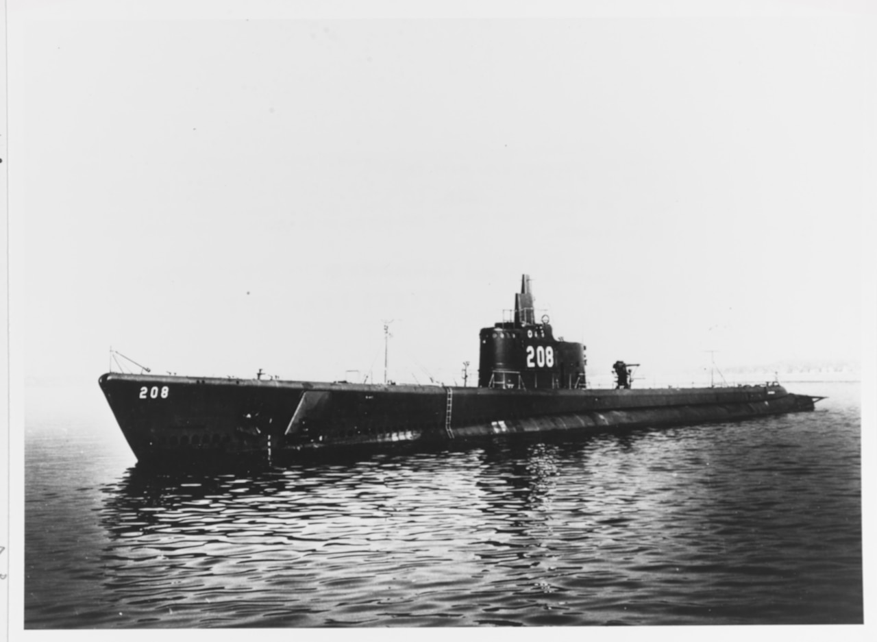 A 1940's era submarine glides across water.