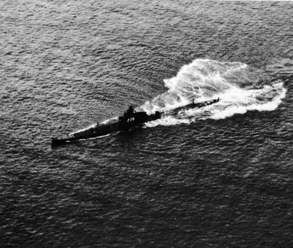 A 1940's era submarine chugs along above water.