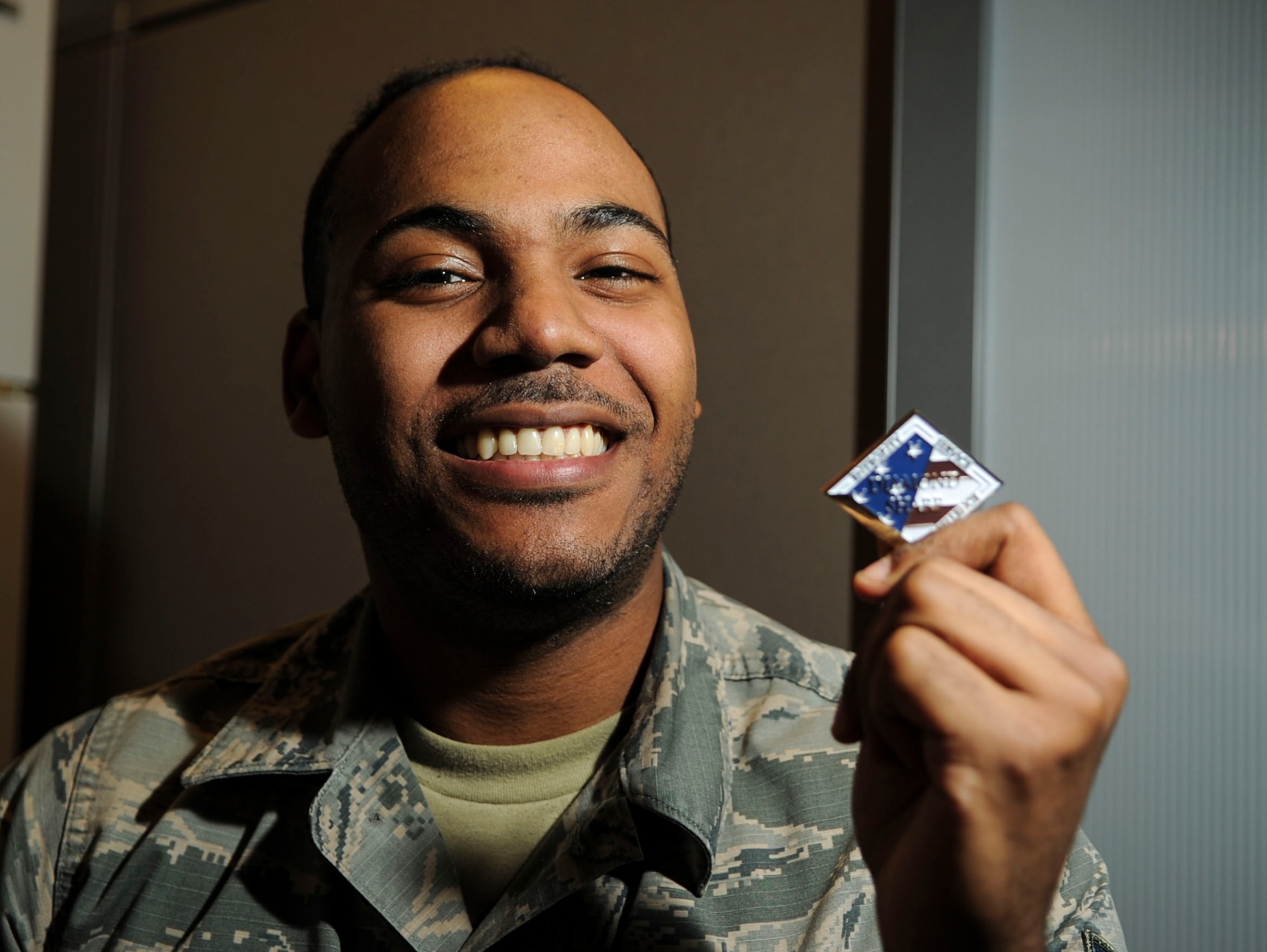 Airman 1st Class Bendali Eugene, Communications Information Group knowledge manager, is presented with the Diamond Sharp Award by First Sgts Senior Master Sgt. William Schipper and Master Sgt. Juan Villa at the National Air and Space Intelligence Center on Wright-Patterson Air Force Base, Ohio, Dec. 18, 2019. The Diamond Sharp Award recognizes Airmen who have actively demonstrated their commitment to Air Force values or have gone above and beyond in helping others. (U.S. Air Force photos by Staff Sgt. Seth Stang)